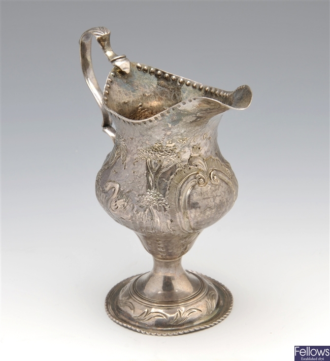 George III silver cream jug with embossed pastoral scene, London 1783.