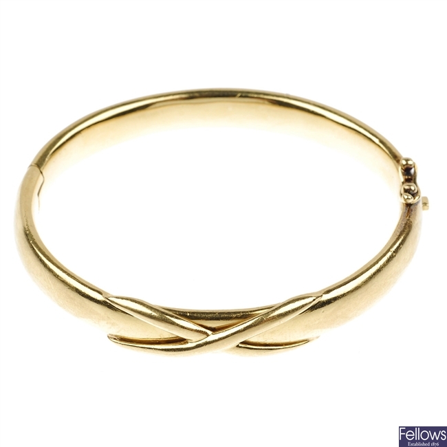(525755-1-A) An 18ct gold hinged bangle with embossed cross design.