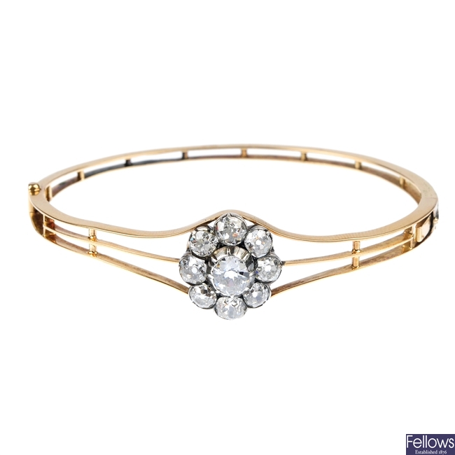 An early 20th century gold and diamond cluster bangle.
