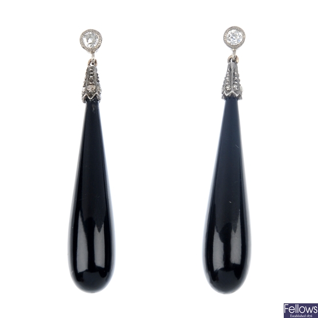A pair of onyx and diamond ear pendants.