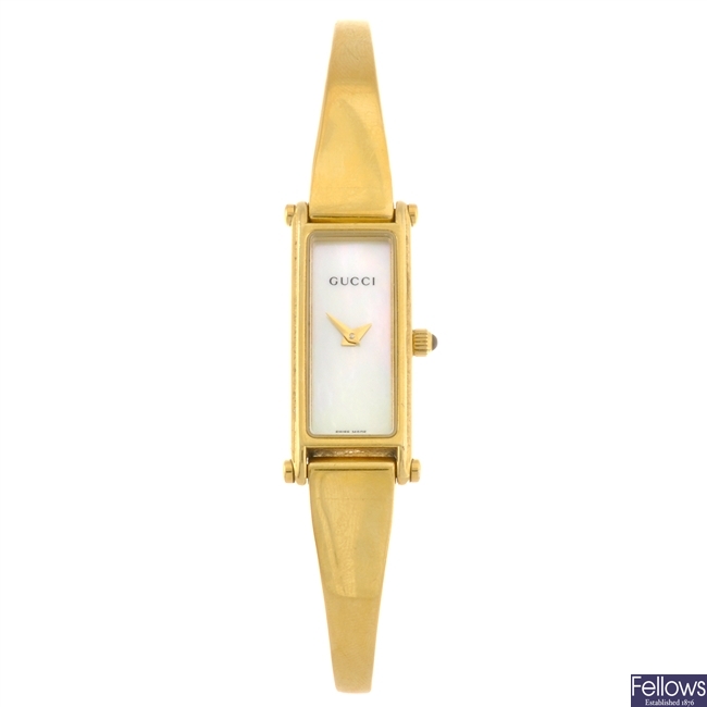 A gold plated quartz lady's Gucci 1500L bangle watch.