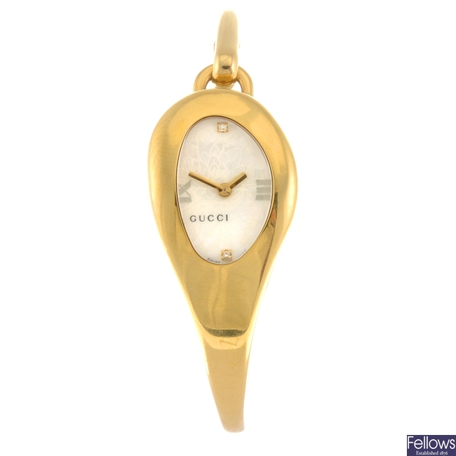 A gold plated quartz lady's Gucci 103 bangle watch.