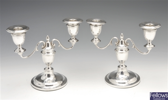 An Edwardian pair of small silver twin branch candelabra.