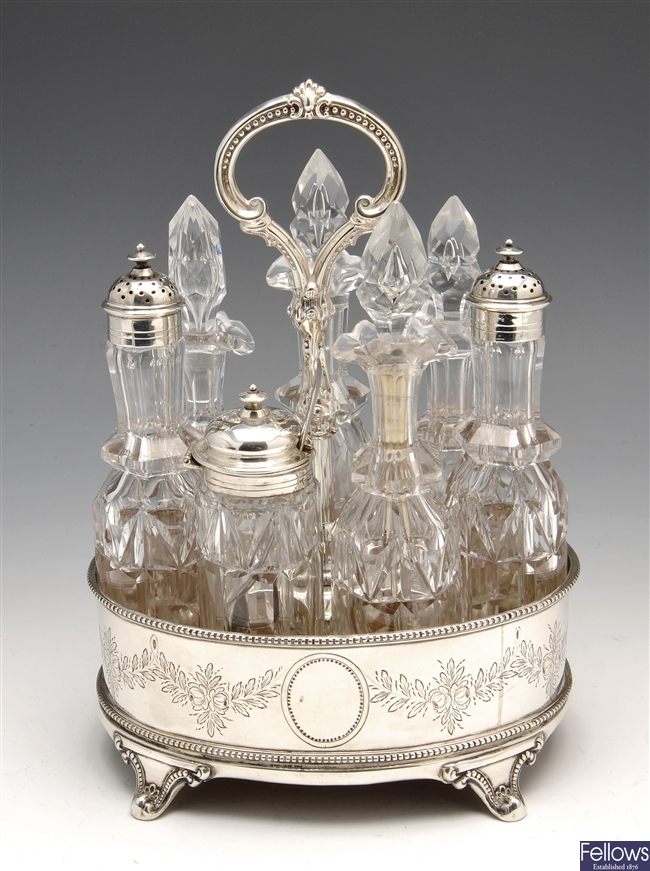 A Victorian silver cruet stand with various glass bottles.
