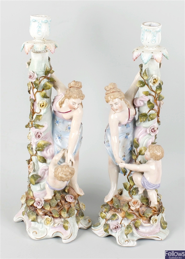 A pair of German porcelain figural candlesticks