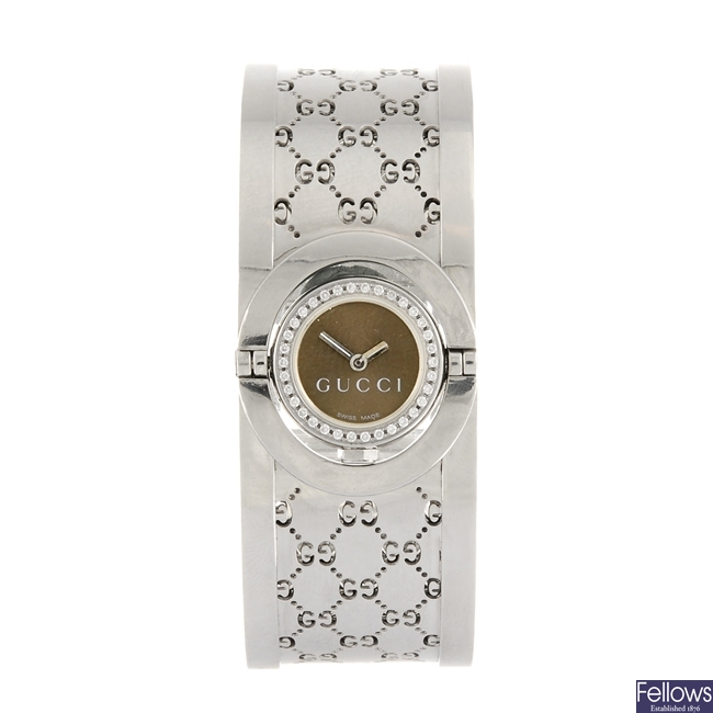 A stainless steel quartz lady's Gucci diamond set Twirl bangle wrist watch.