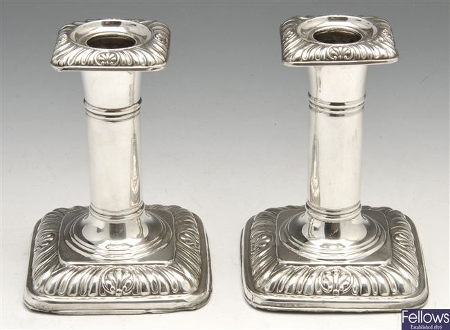 A late Victorian pair of silver mounted candlesticks.