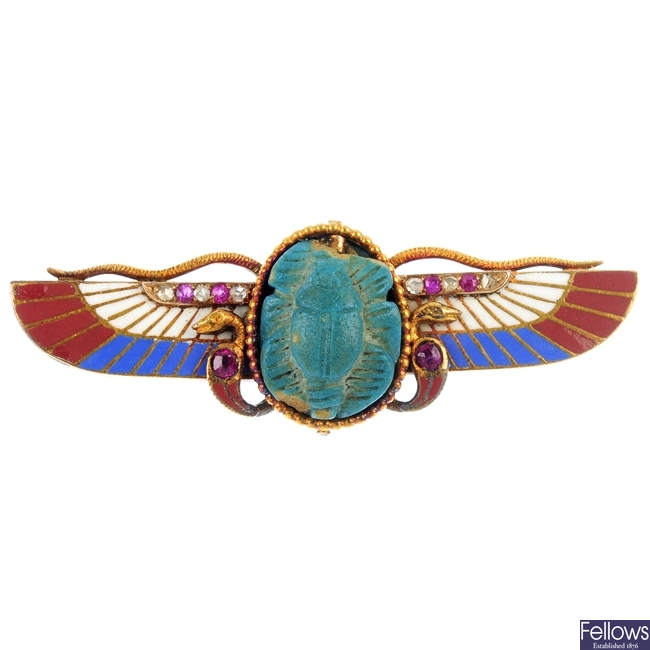 An Art Deco 18ct gold Egyptian Revival gem-set winged scarab brooch.