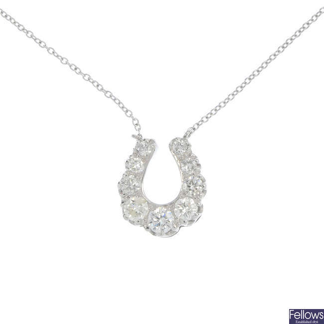 A diamond horseshoe pendant with chain.