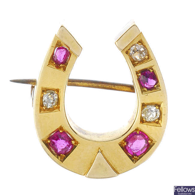 A late Victorian 15ct gold diamond and ruby horseshoe brooch, circa 1880.