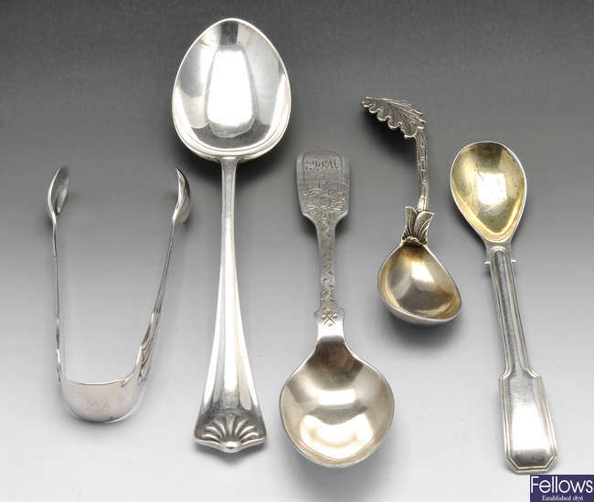 Assorted silver spoons, a pair of sugar tongs & two ingots.