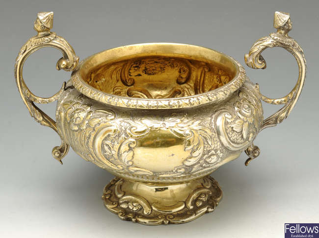 A George III silver-gilt twin handled sugar basin.