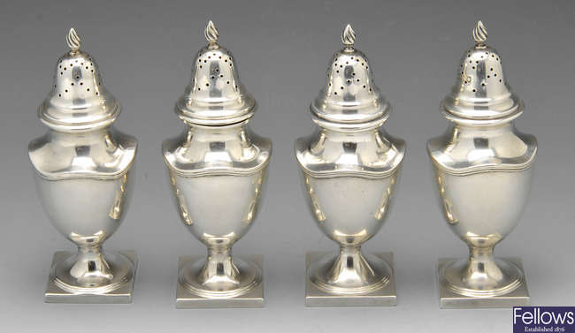 A set of four Edwardian silver casters.