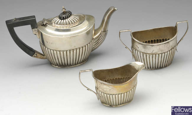 An Edwardian three piece bachelor tea set & a cream jug.