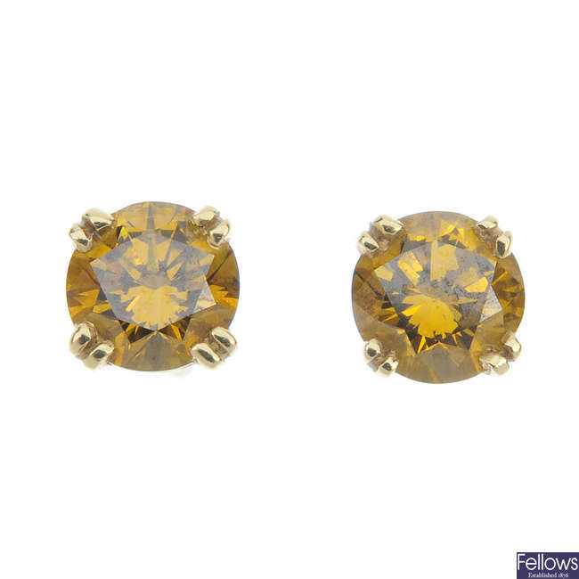 A pair of brownish yellow coloured diamond single-stone ear studs.