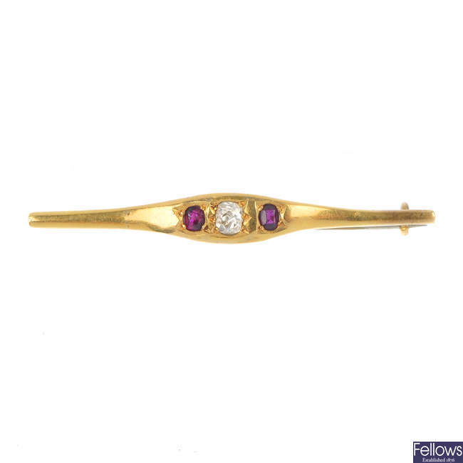 An early 20th century gold diamond and ruby three-stone bar brooch.