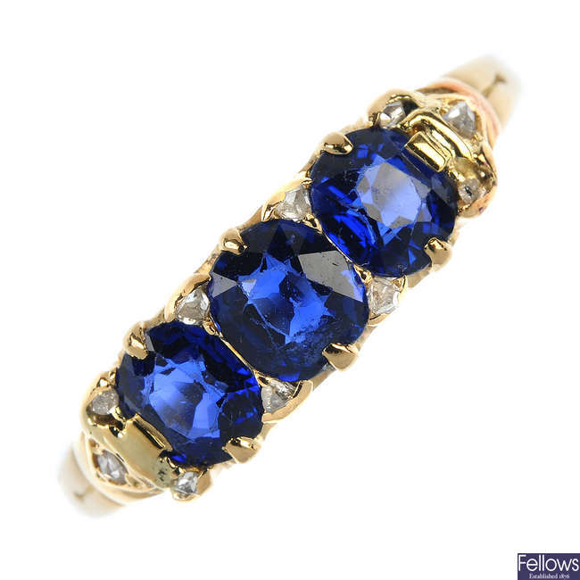 An early 20th century 18ct gold sapphire three-stone and diamond accent ring.
