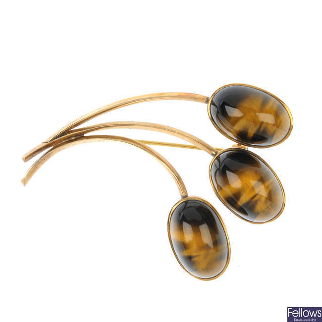 A tiger's-eye brooch and a 9ct gold foliate brooch.