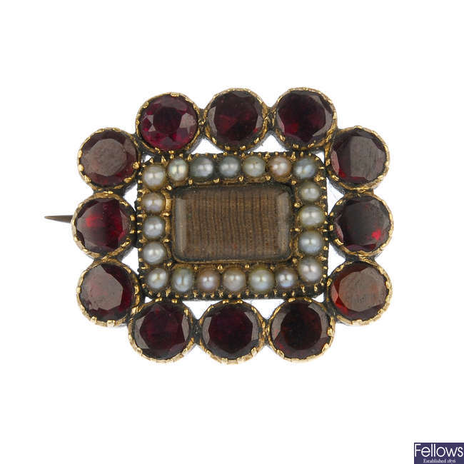 A late 19th century gold garnet and split pearl memorial brooch.