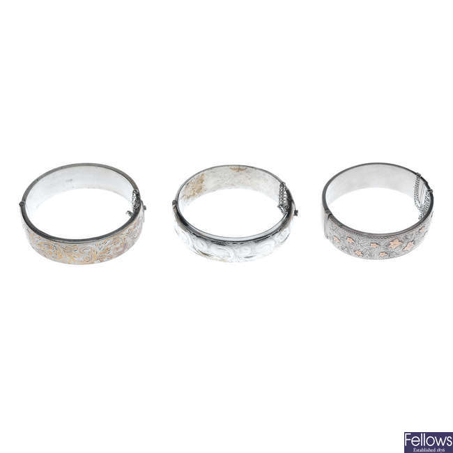 Three silver hinged bangles.