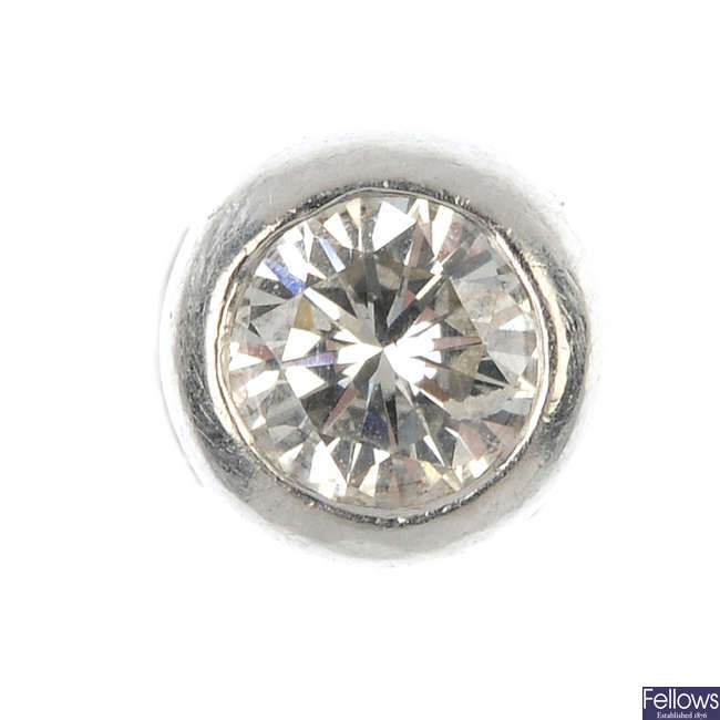 A diamond single-stone ear stud and a loose diamond.