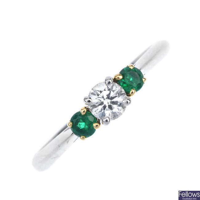 TIFFANY & CO. - a platinum diamond and emerald three-stone ring. 
