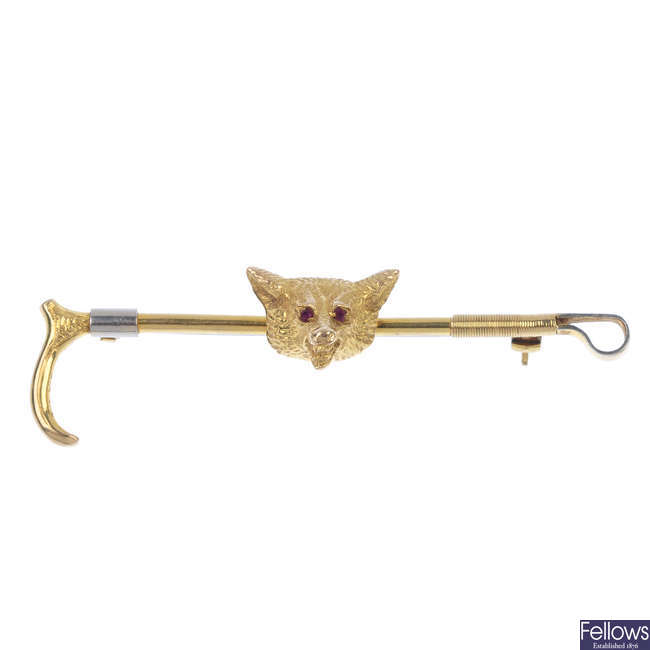 A mid 20th century 9ct gold ruby fox and riding crop brooch.