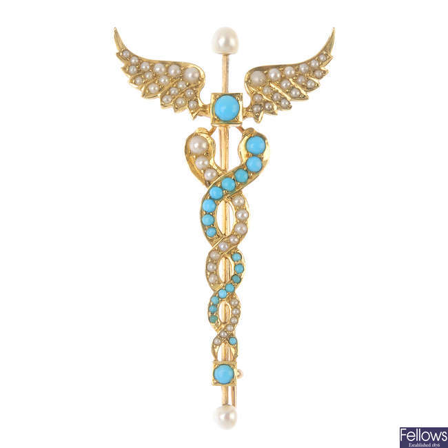 An early 20th century gold turquoise and split pearl caduceus brooch.