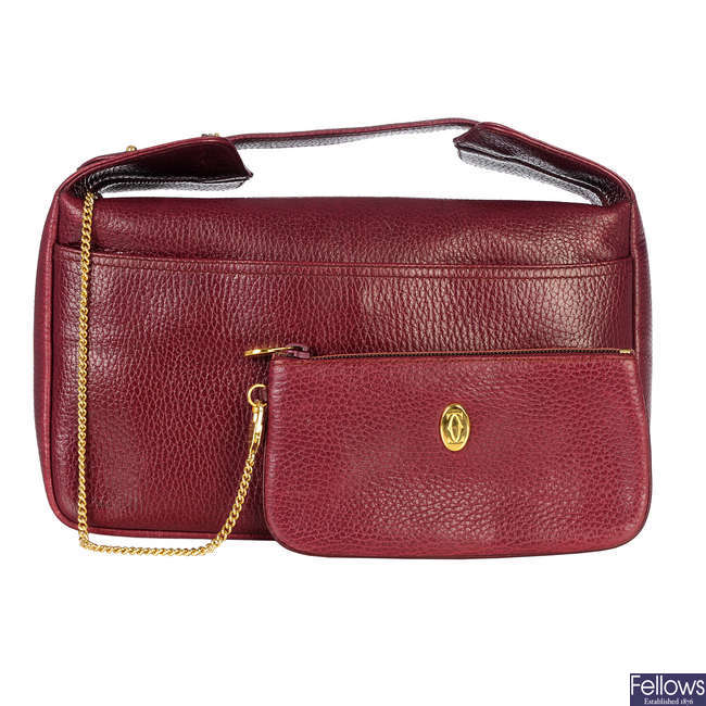 CARTIER - a Bordeaux leather cosmetics bag with interior purse.