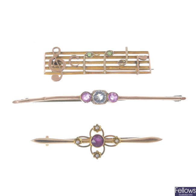 An early 20th century 9ct gold musical notes 'Dearest' brooch and two others.