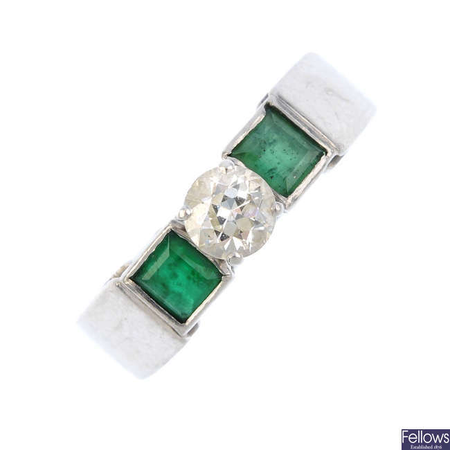 A diamond and emerald three-stone ring.