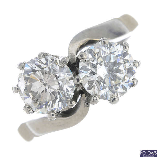 An 18ct gold brilliant-cut fracture-filled diamond two-stone crossover ring.