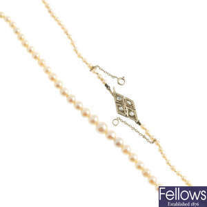A cultured pearl necklace with gold diamond clasp.