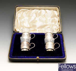A cased set of four silver mounted tot cups, etc.