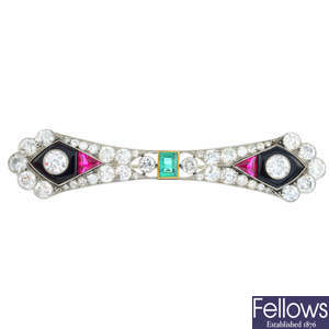 An Art Deco diamond, emerald, onyx and synthetic ruby bow brooch.