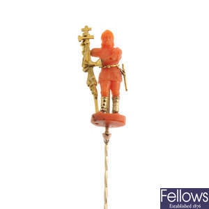 A late 19th century carved coral and gold stickpin.