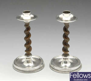 A pair of early 20th century silver mounted and oak barley twist candlesticks.