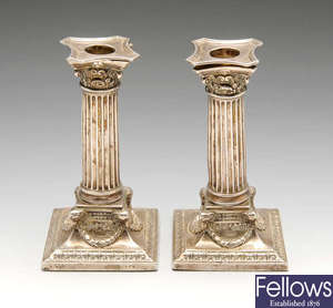 A pair of late Victorian silver mounted candlesticks.