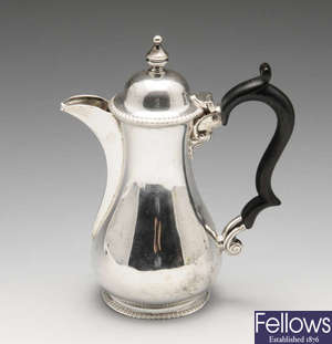 An George V silver hot water pot, plus a matching sugar bowl and cream jug.