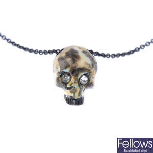 A diamond and enamel skull pendant, with chain.