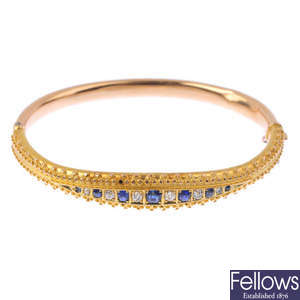 An early 20th century 15ct gold sapphire and diamond hinged bangle.