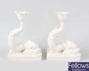A pair of Wedgwood white glazed candlesticks each modelled as a dolphin, together with a Wedgwood Queens ware box and cover of square form.