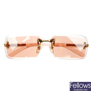 VERSACE - a pair of pink rimless sunglasses.