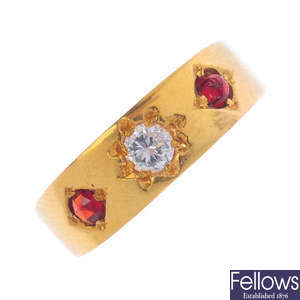 A cubic zirconia and red paste three-stone ring.