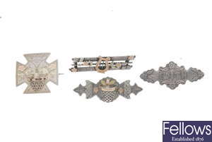 Eighteen late 19th to early 20th century silver brooches.
