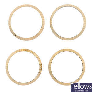 ROLEX - a group of three yellow metal fluted bezels and another in the style of Rolex.