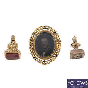 Two seals and a late 19th century swivel portrait memorial brooch, with later added spiral surround.