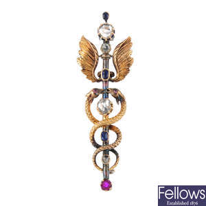 A late Victorian 15ct gold and silver diamond and gem-set caduceus brooch.