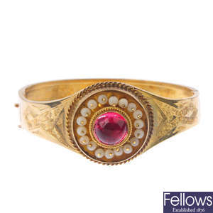 A late 19th century 18ct gold gem-set hinged bangle.