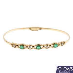 A 9ct gold emerald and diamond hinged bangle.